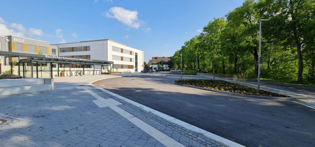 Zufahrtsstraße zum Haupteingang mit bepflanzter zentraler Beetfläche