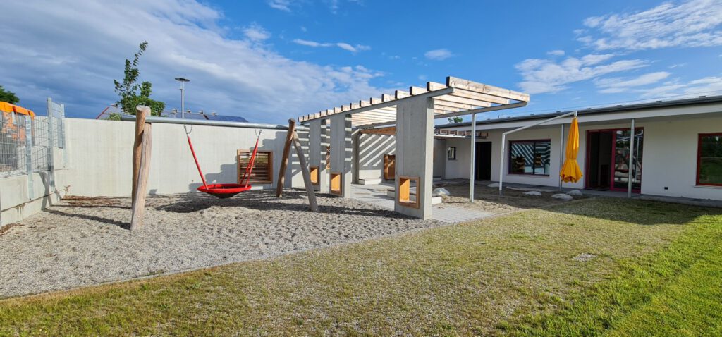 Spielbereich mit Vogelnestschaukel und Sandkasten