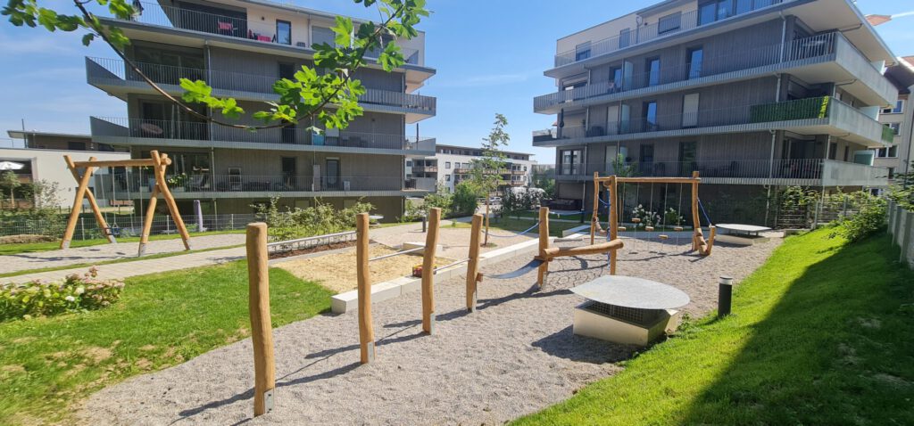 zentraler Spielbereich mit Schaukeln und Parcour, aus Holzstämmen