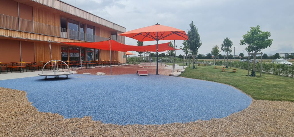 Spielbereich mit Wipp-Spiel und Sandkasten mit Sonnensegel