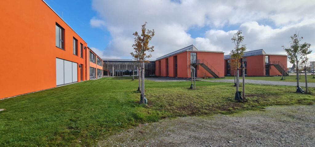 Gebäude mit Rasenfläche und neuen Baumpflanzungen