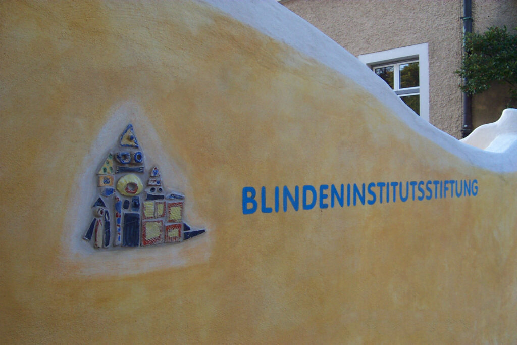 Schriftzug des Blindeninstituts auf gelber Wand