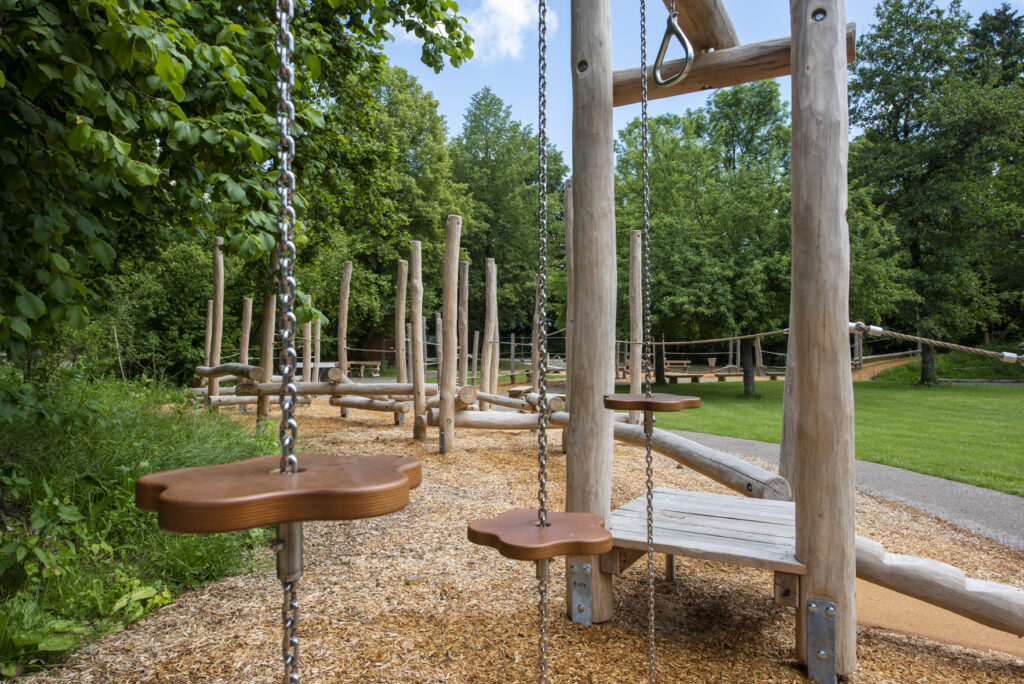 Spielparcour aus Holz mit verschiedenen Spielmöglichkeiten, Fallschutz aus Hackschnitzel