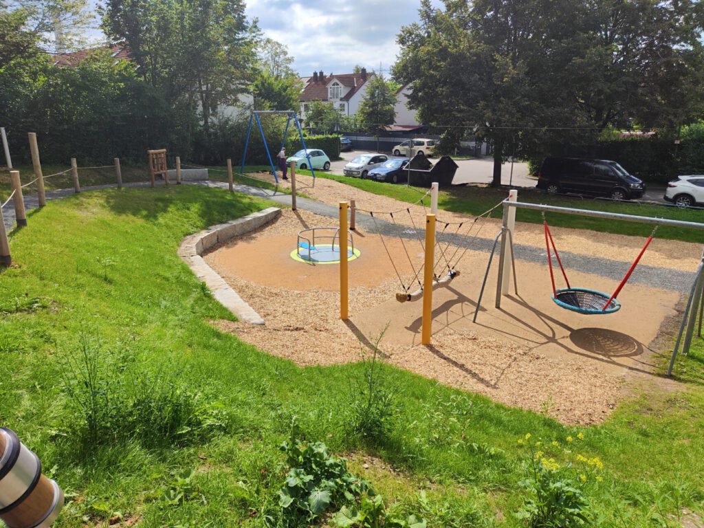 Spielfläche mit Rohlstuhlkarusell, Tampenschaukel und einer Vogelnestschaukel
